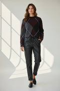 Plaza d'Amanté model wearing an argyle knit sweater and black faux leather joggers with a drawstring waist