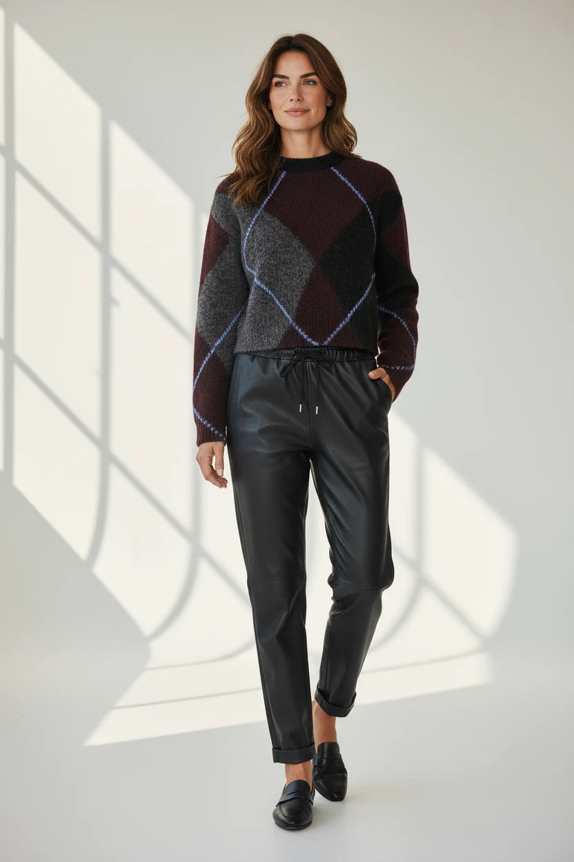 Plaza d'Amanté model wearing an argyle knit sweater and black faux leather joggers with a drawstring waist
