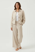 A model wearing a Plaza d'Amanté beige linen-blend button-down jacket and matching wide-leg drawstring trousers.