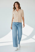 Plaza d'Amanté beige ribbed knit short sleeve polo cardigan with a collared button-down front worn with blue jeans.