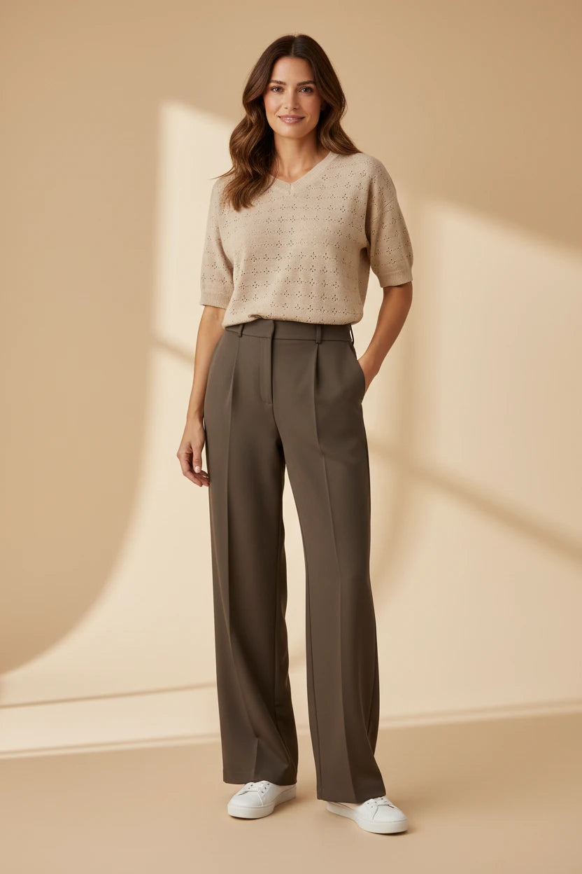 Plaza d'Amanté beige pointelle knit V-neck sweater paired with olive green high-waisted wide-leg tailored trousers.