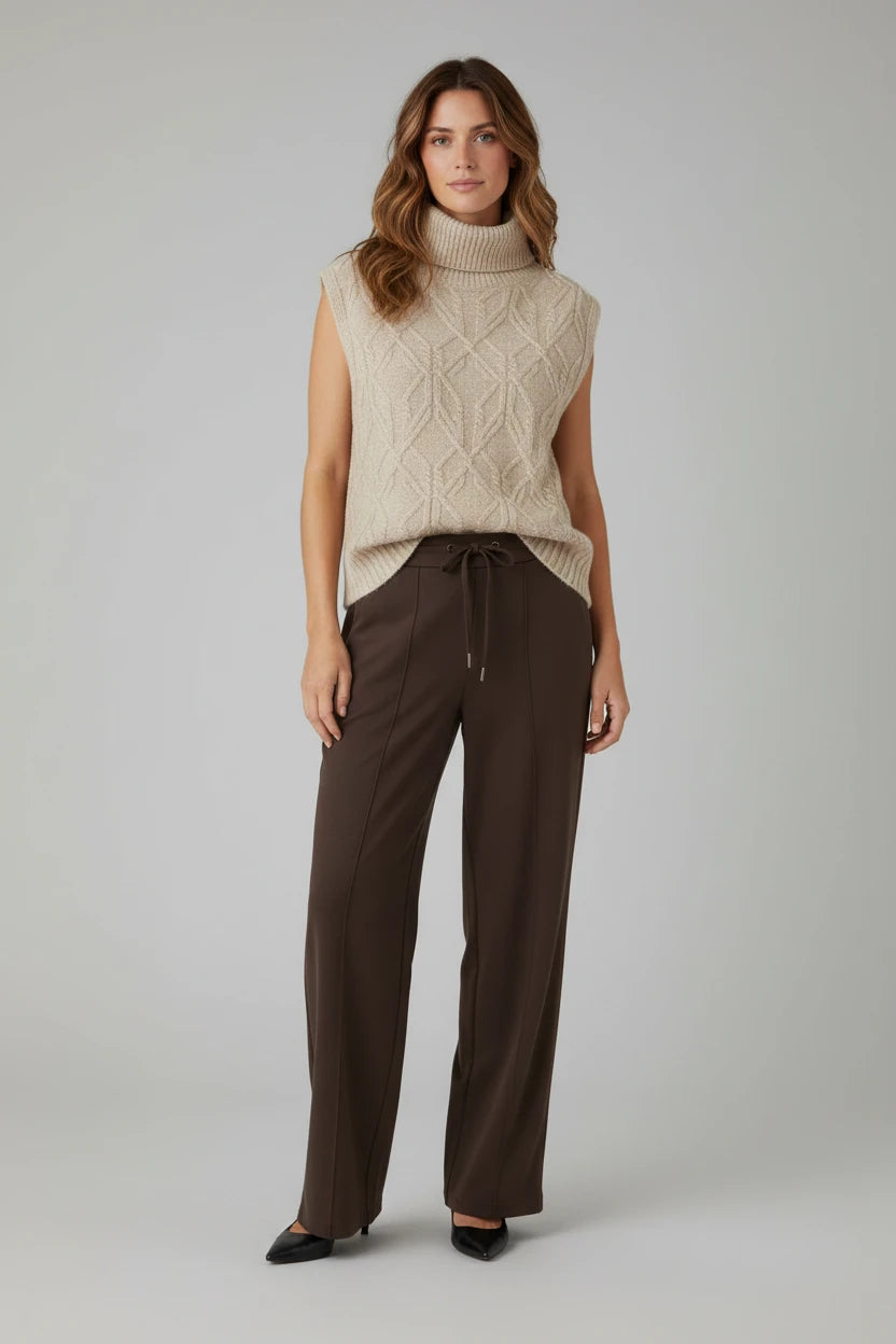 Plaza d'Amanté beige diamond-knit sleeveless turtleneck sweater vest paired with dark brown wide-leg trousers