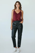 Plaza d'Amanté black faux leather joggers with an elastic waist, worn by a woman with a burgundy lace camisole.
