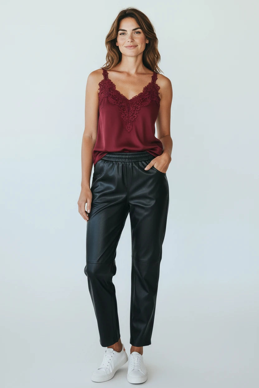 Plaza d'Amanté black faux leather joggers with an elastic waist, worn by a woman with a burgundy lace camisole.