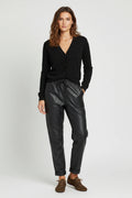 Plaza d'Amanté model wearing a black V-neck knit cardigan and black faux leather joggers with a drawstring waist.