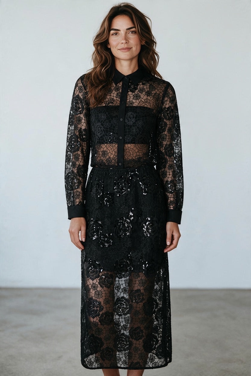 A model wearing a Plaza d'Amanté black floral lace midi shirt dress with long sleeves and sequin skirt details.