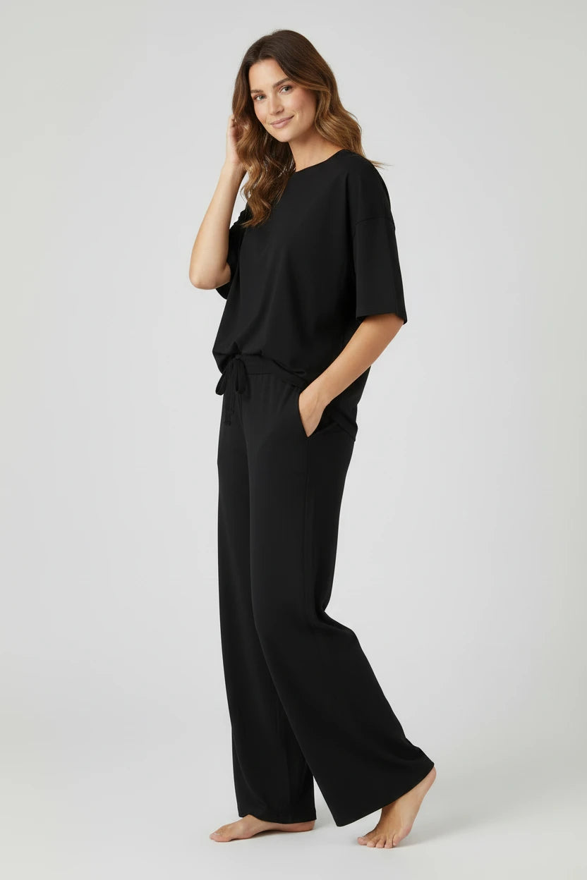 Plaza d'Amanté black relaxed fit lounge set with a crew neck top and wide leg trousers featuring side pockets.