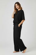 Plaza d'Amanté black relaxed fit lounge set with a crew neck top and wide leg trousers featuring side pockets.