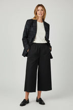 Plaza d'Amanté black wide-leg cropped trousers with deep pockets worn by a model with a blazer and loafers.