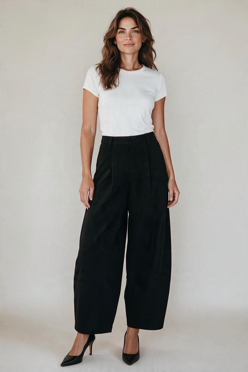 Plaza d'Amanté high-waisted black wide-leg tailored trousers worn by a woman with a white t-shirt and black heels.