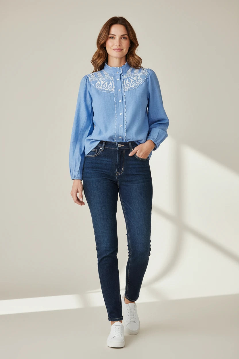 Plaza d'Amanté blue long sleeve button down blouse with white embroidery on the collar and yoke worn with jeans