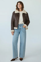 Model wearing a Plaza d'Amanté brown faux leather aviator jacket with cream faux shearling lining and collar