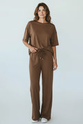 Plaza d'Amanté brown relaxed fit lounge set with a dropped shoulder t-shirt and wide-leg trousers on a woman.