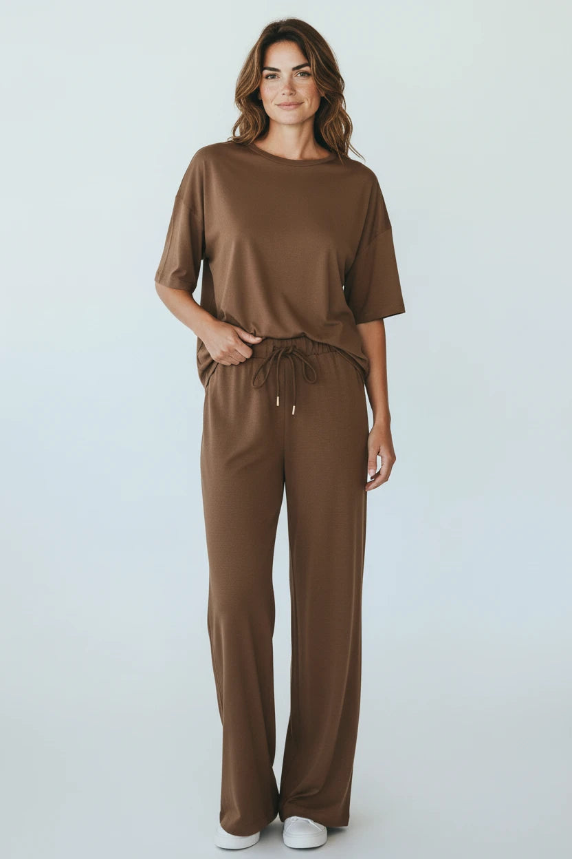 Plaza d'Amanté brown relaxed fit lounge set with a dropped shoulder t-shirt and wide-leg trousers on a woman.