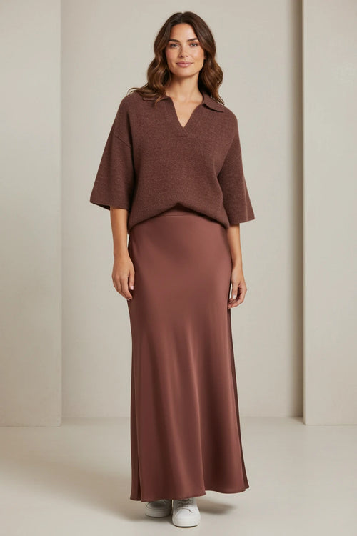 Plaza d'Amanté model wearing a chocolate brown knit polo sweater and a matching mocha satin maxi skirt with sneakers.