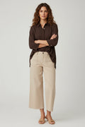 Plaza d'Amanté model wearing a chocolate brown button-down shirt and beige high-rise wide-leg cropped utility pants.