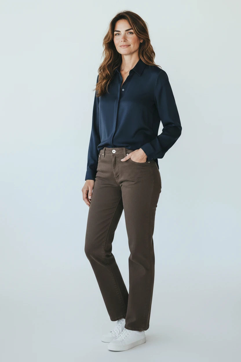 Plaza d'Amanté model wearing a navy button-down shirt and straight-leg brown trousers with white sneakers.