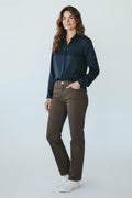 Plaza d'Amanté model wearing a navy button-down shirt and straight-leg brown trousers with white sneakers.