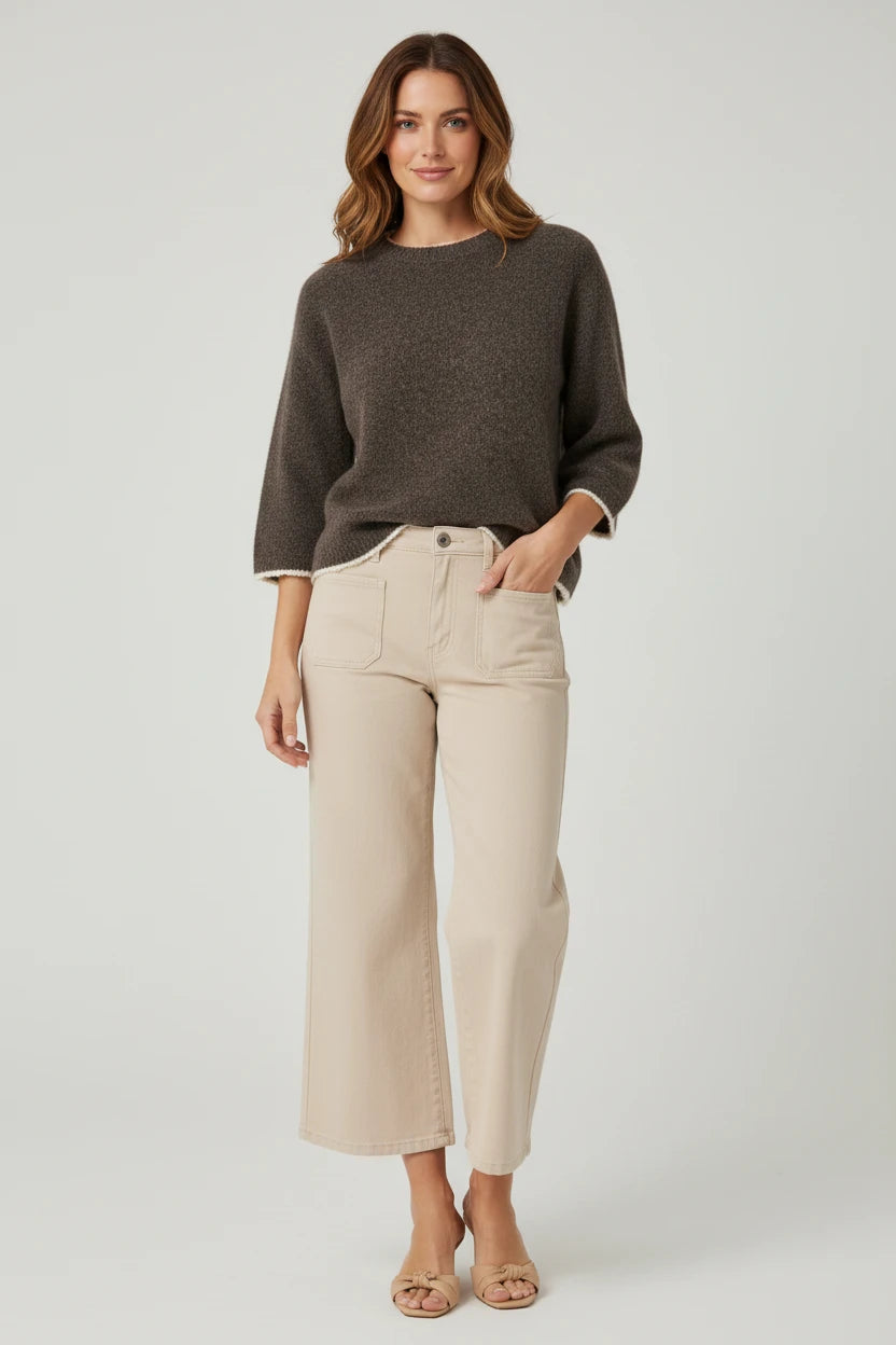 Plaza d'Amanté espresso brown knit sweater with cream trim worn with beige cropped wide-leg denim pants by a model.