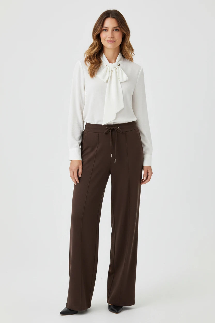 Plaza d'Amanté high-waisted wide-leg trousers in chocolate brown with a drawstring waist and front seam detail.