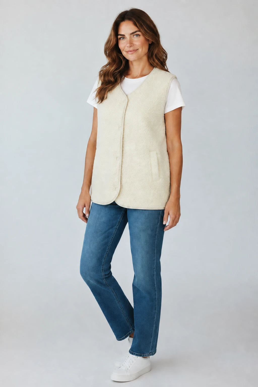 Plaza d'Amanté cream textured fleece vest with snap buttons and side pockets worn over a white tee and blue jeans.