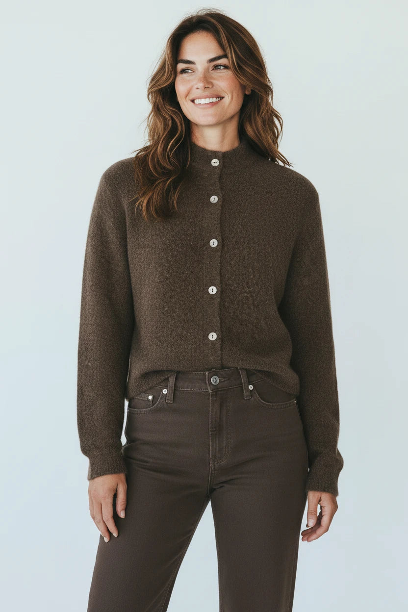A smiling woman wearing a Plaza d'Amanté espresso brown mock neck knit cardigan with a button-down front.