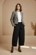 Plaza d'Amanté model wearing a grey glen check cropped blazer, white t-shirt, and black wide-leg trousers.