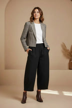Plaza d'Amanté model wearing a grey glen check cropped blazer, white t-shirt, and black wide-leg trousers.