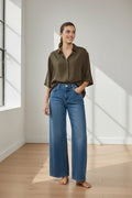 Plaza d'Amanté high-rise wide-leg medium-wash denim jeans worn by a woman with an olive green button-down shirt.