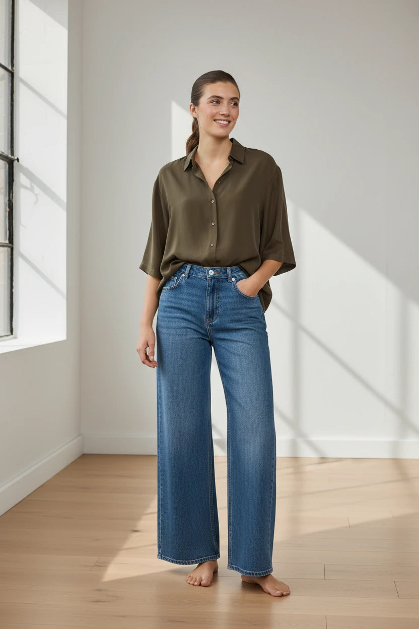 Plaza d'Amanté high-rise wide-leg medium-wash denim jeans worn by a woman with an olive green button-down shirt.
