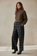 Plaza d'Amanté high-waisted wide-leg trousers in dark grey and black plaid, styled with a brown turtleneck sweater.