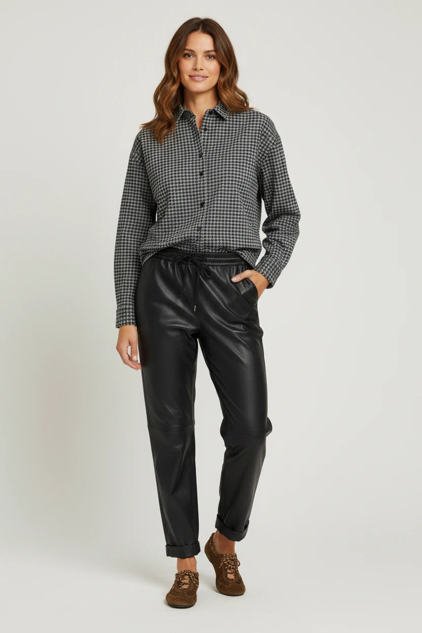 Plaza d'Amanté houndstooth button-down shirt paired with black faux leather joggers on a model