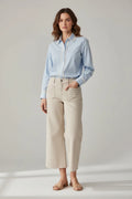 Plaza d'Amanté light blue cotton button-down shirt with white lace trim on placket and cuffs worn with beige trousers.