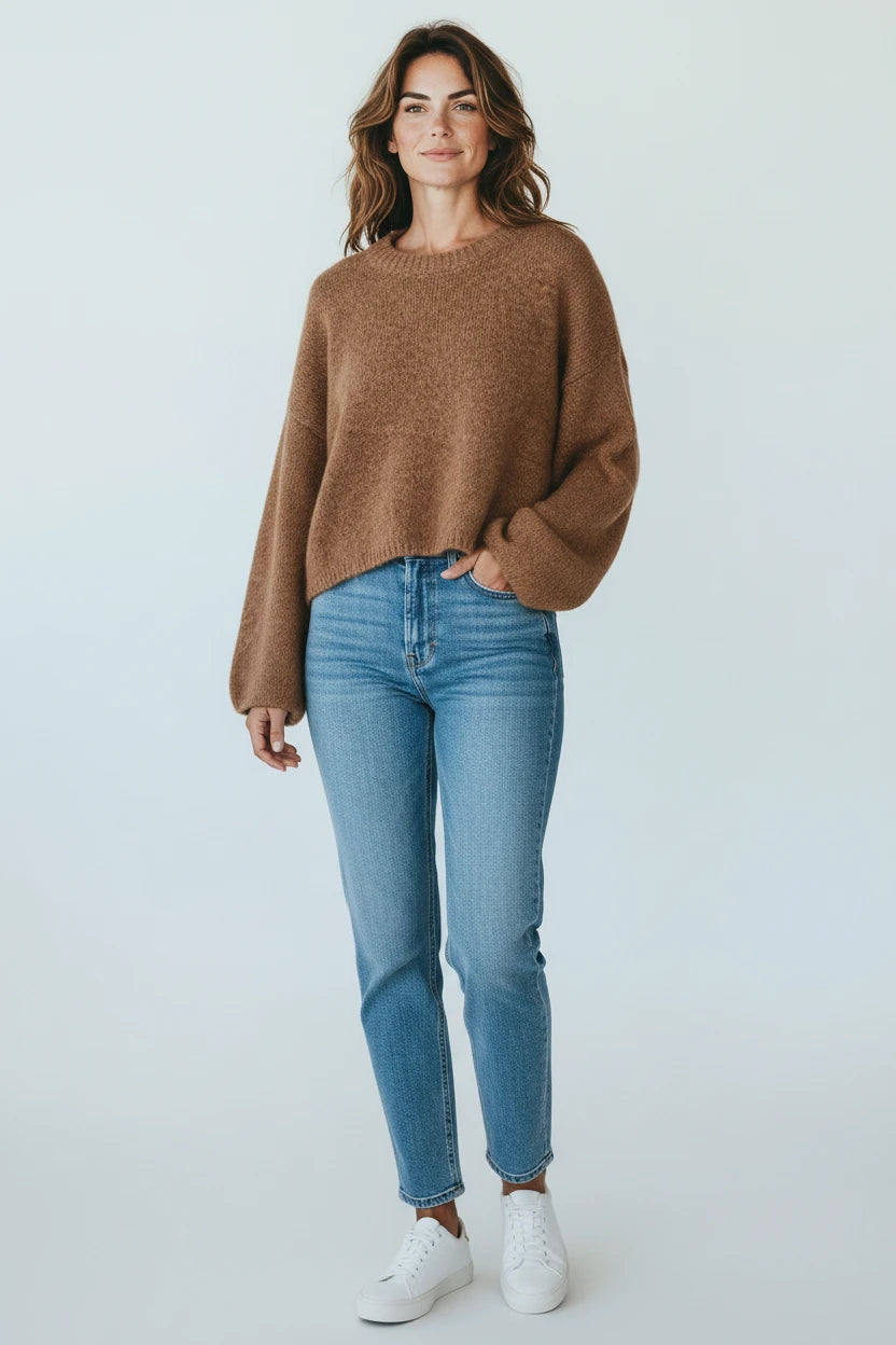 Model wearing a Plaza d'Amanté mocha brown crewneck knit sweater with dropped shoulders and cropped fit with blue jeans