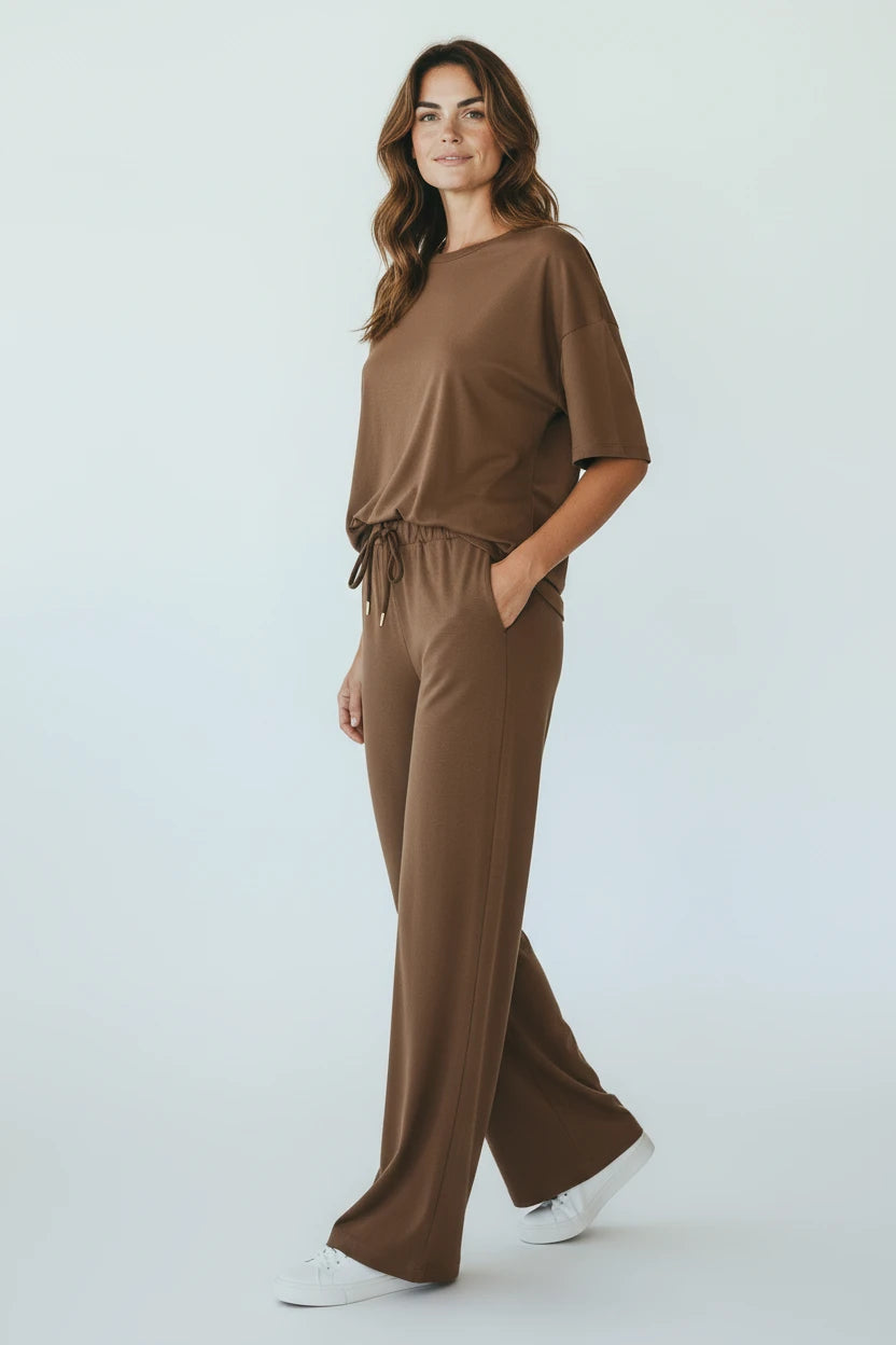 Plaza d'Amanté mocha brown two-piece lounge set with a crewneck top and wide-leg trousers on a smiling woman.