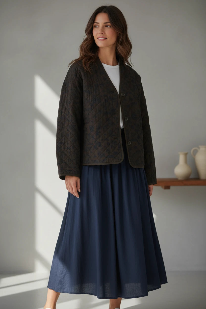 Plaza d'Amanté olive brown diamond-quilted button-front jacket with a V-neck collarless design worn by a woman.