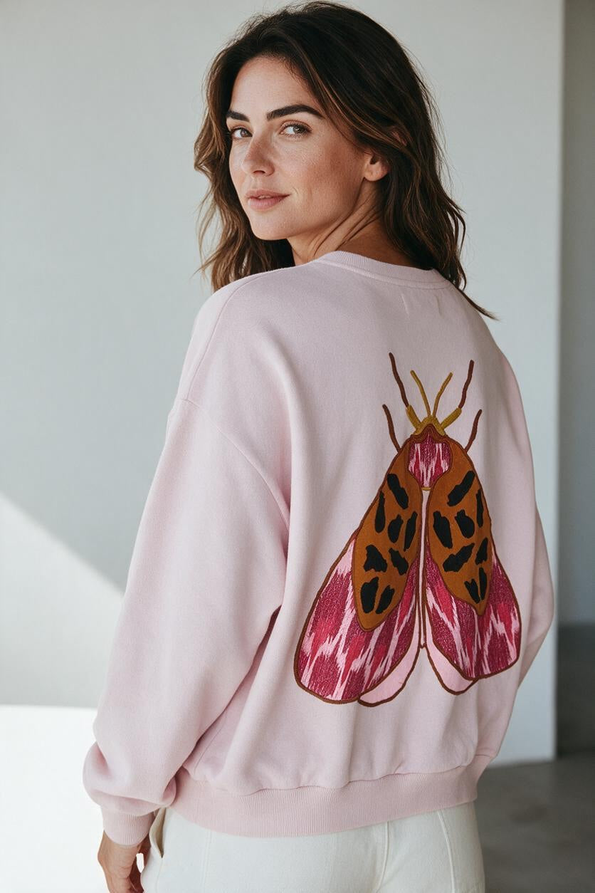 Plaza d'Amanté pastel pink cotton-blend pullover sweatshirt featuring a detailed moth graphic print on the back.