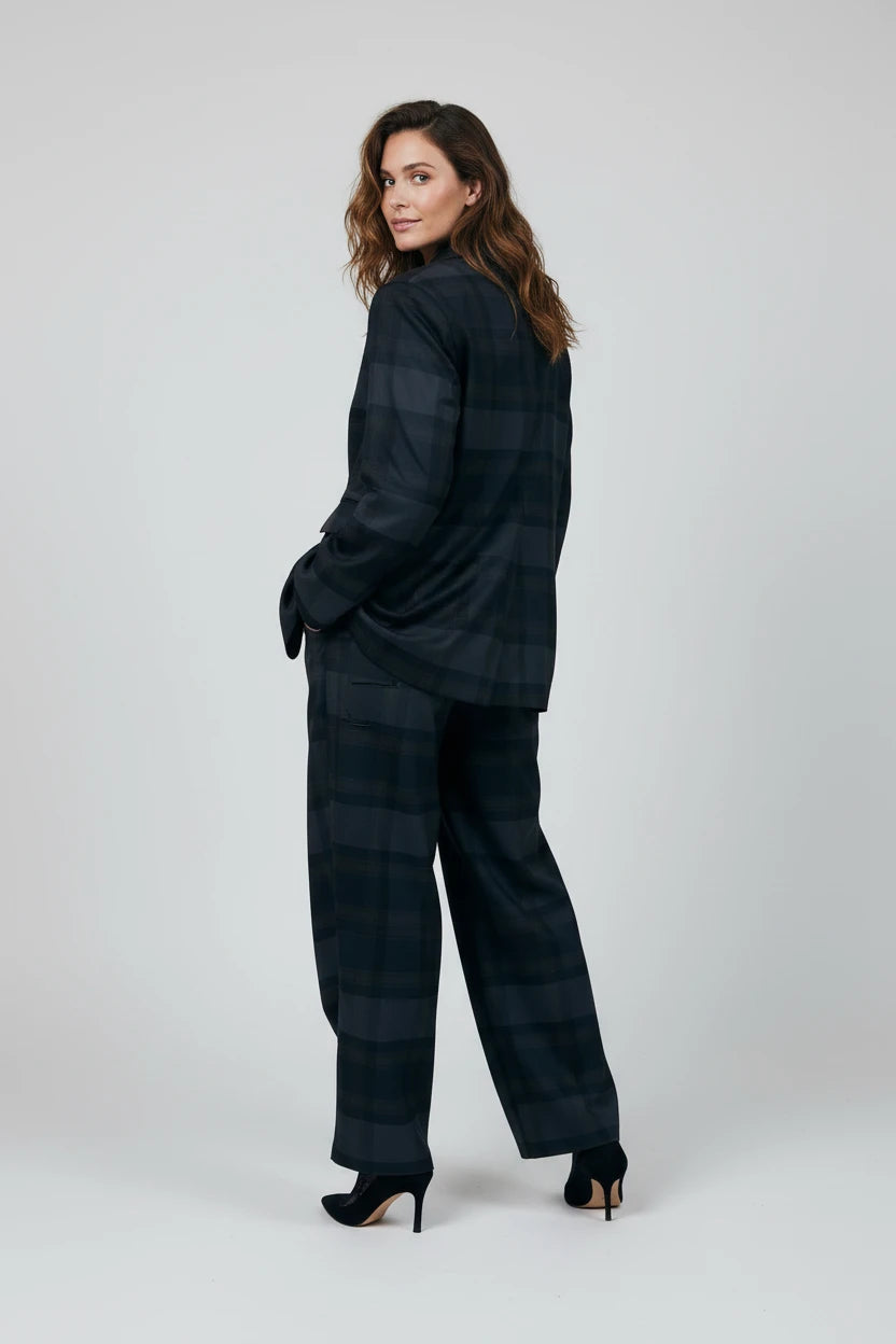 Model wearing a Plaza d'Amanté charcoal and midnight blue plaid tailored blazer and wide-leg trouser suit set.
