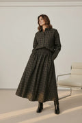 Plaza d'Amanté two-piece set featuring a dark olive and charcoal plaid button-down shirt and a matching midi skirt.