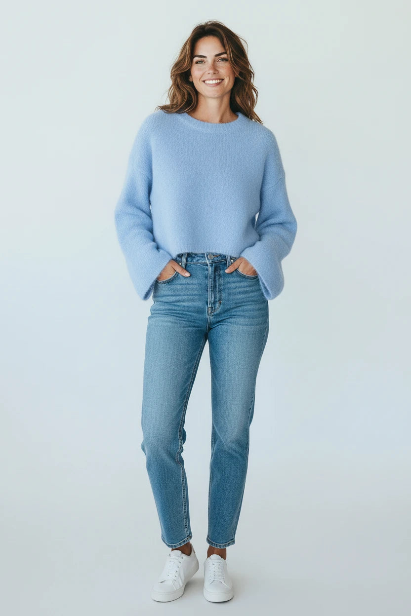 A woman wearing a Plaza d'Amanté powder blue fuzzy knit crewneck sweater with drop shoulders and blue denim jeans.