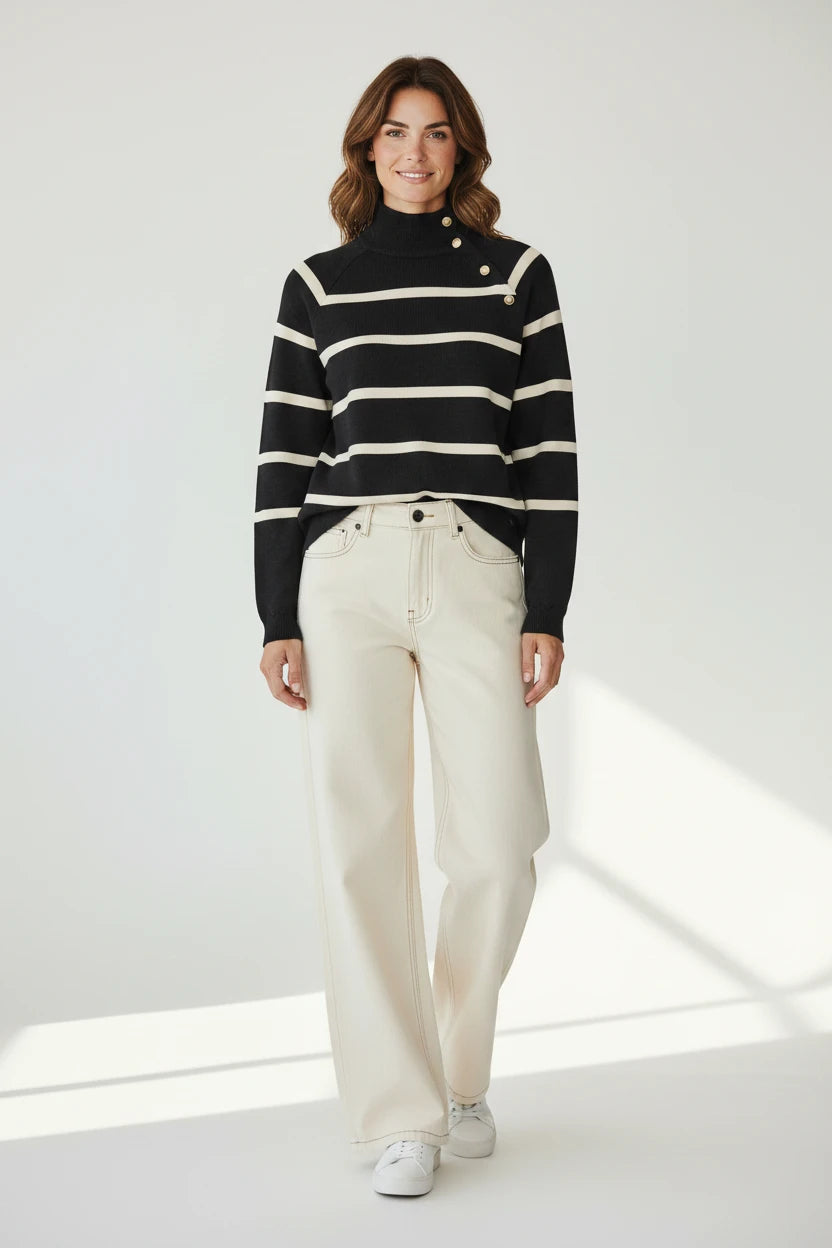 Plaza d'Amanté striped mock neck sweater in black and cream with gold shoulder buttons worn with cream wide-leg jeans