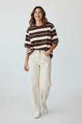 Plaza d'Amanté relaxed fit chocolate brown and cream striped cotton t-shirt worn by a smiling woman with cream jeans
