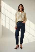 Plaza d'Amanté model wearing a yellow striped button-down shirt and high-waisted dark-wash straight leg denim jeans
