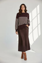 Plaza d'Amanté espresso striped knit sweater and matching chocolate brown satin midi skirt worn by a model.