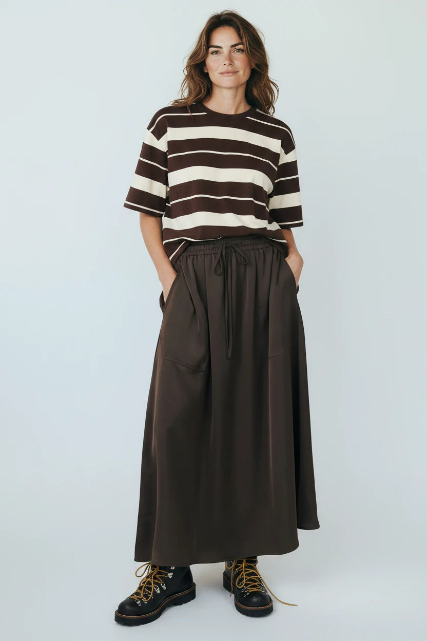 Plaza d'Amanté model wearing a chocolate brown and cream striped t-shirt with a matching brown maxi skirt and boots.